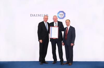 在負(fù)責(zé)戴姆勒大中華區(qū)業(yè)務(wù)的董事會(huì)成員唐仕凱先生(左)的見證下，TUV 南德意志大中華集團(tuán)高級(jí)副總裁朱文才先生(右)為戴姆勒卡客車（中國）有限公司總裁兼首席執(zhí)行官羅伯特先生(中)頒發(fā)證書